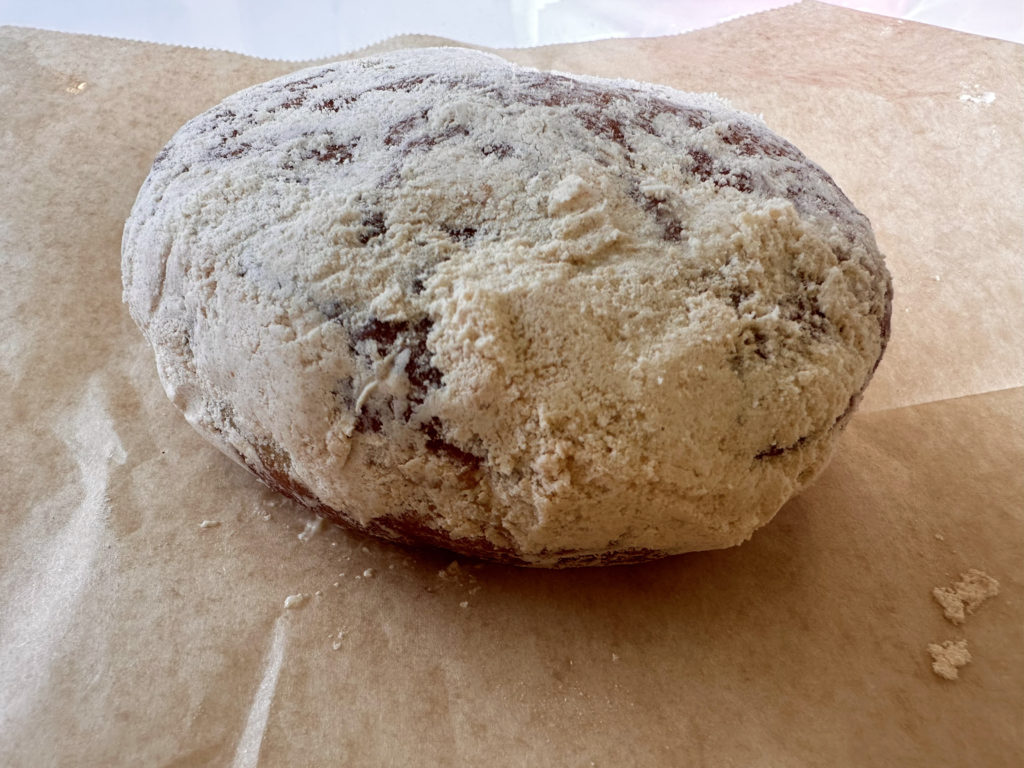 A peanut butter and jelly donut from Blue Star Donuts in Portland, Oregon. Coated in peanut butter flour and filled with jelly with a spice kick.