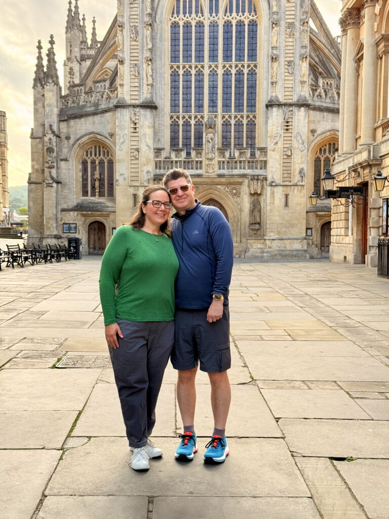 A white couple standing in front of an abbey smiling