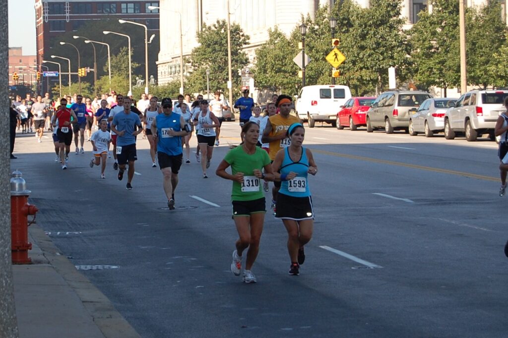 A group of people running on a sunshine filled street